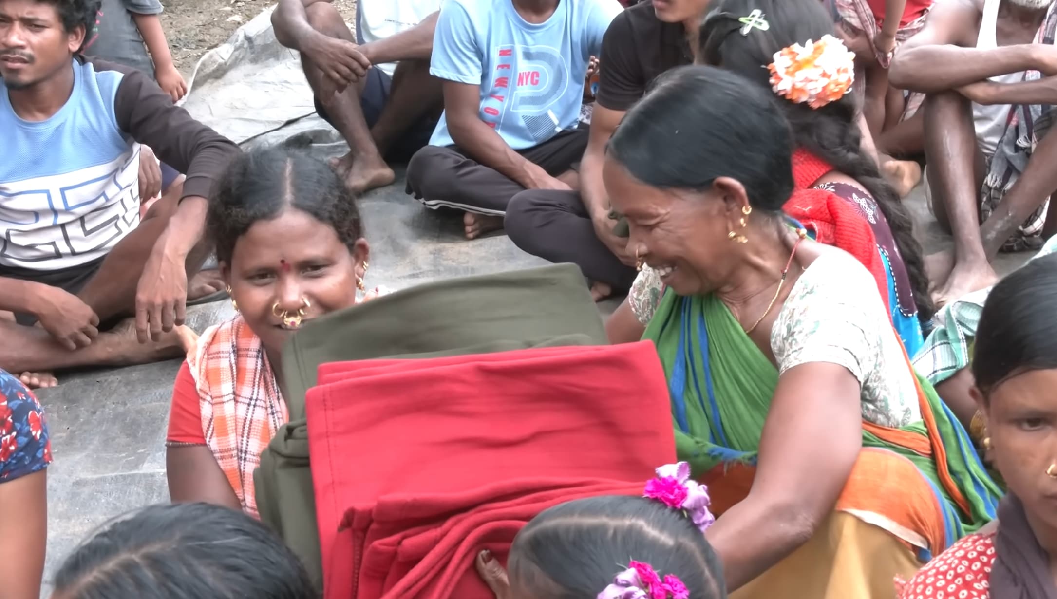 Tribal families receiving warm rugs donated by Pawan Kalyan